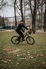 Fototapeta na wymiar A focused businessman in casual attire taking a break to ride his bike in an urban park setting.