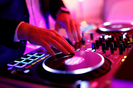 Hand eines Discjockeys an einem Mischpult