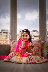 Beautiful Young Indian girl smiling  and dressed up in traditional indian Rajasthani wear in a royal background 