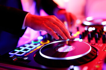 Hand eines Discjockeys an einem Mischpult