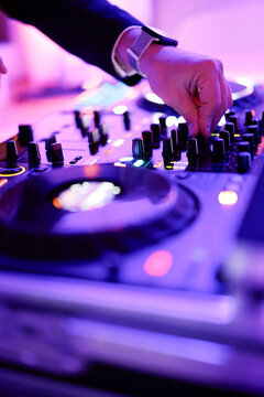 Hand eines Discjockeys an einem Mischpult