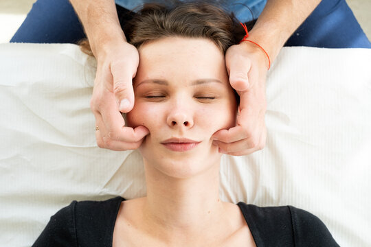 Facial massage. Doctor giving facial massage to young girl