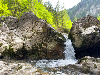 A small waterfall between the rocks on a mountain river