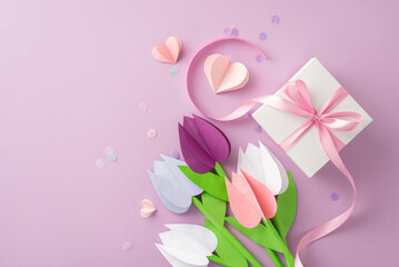 Artisanal Mother's Day greeting. Top view of origami tulips, a ribbon-wrapped gift, diminutive hearts, and soft confetti on a gentle lilac setting, with a blank area for text or advertising