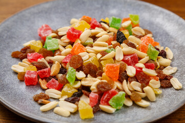 Mix of dried fruits and nuts on a gray plate. horizontal