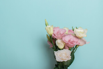 A bouquet of pink and white flowers of eustoma, lisianthus on a light blue background with a place...