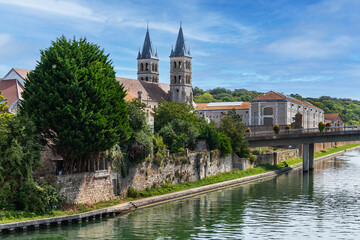 Fototapeta na wymiar Beautiful view of the banks of the Seine River in the city of Melun and the Collegiate Church of Notre Dame. Melun, Seine-et-Marne department, France. 