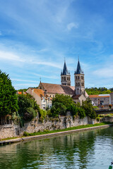 Fototapeta na wymiar Beautiful view of the banks of the Seine River in the city of Melun and the Collegiate Church of Notre Dame. Melun, Seine-et-Marne department, France. 