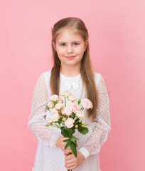 Little girl in white dress holding flowers on pink backgrounds.