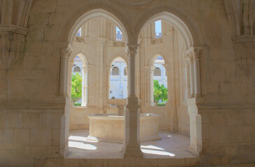 Medieval arches giving way to a cloister with view to a secret garden