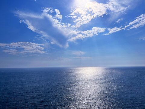 Blue glittering sea and sky clouds 