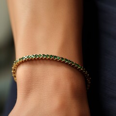 Emerald tennis bracelet with yellow gold on a woman's hand. Closeup image of a beautiful thin gold bracelet with many small emeralds on a soft female hand. Expensive luxury elegant bracelet jewelry. - 760803862