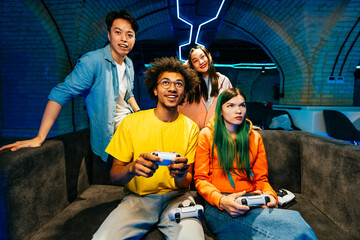 Multiethnic group of young friends playing videogames at home