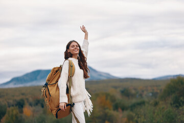 Smiling Woman on Mountain Adventure: Hipster Hiker Enjoying Nature and Freedom on Cliff