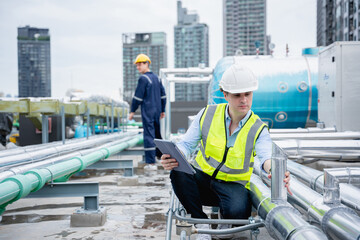 A group of engineers is inspecting the air conditioning cooling system of a large building or...