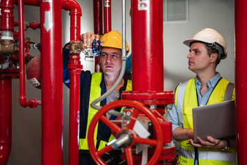Engineers are inspecting the plumbing and water valves inside an industrial facility.