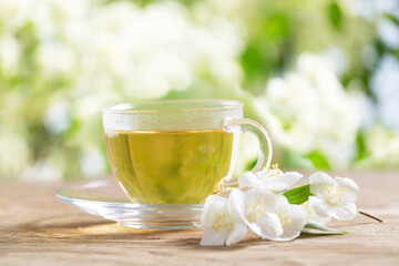 cup of jasmine tea and jasmine flowers - 760815201