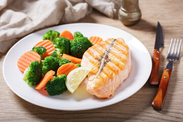 plate of grilled salmon and vegetables - 760815418