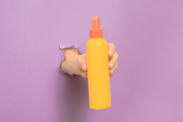 Cosmetic spray container (for skin or hair) in female hand. Cosmetic beauty packaging