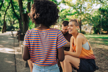 Portrait of a girl sitting with her multicultural friends in a park.