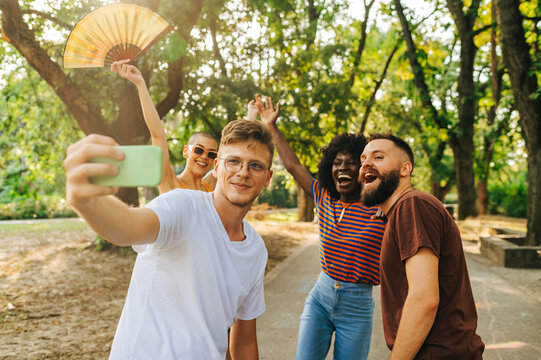 A group of friends celebrating life and taking a selfie together outside.