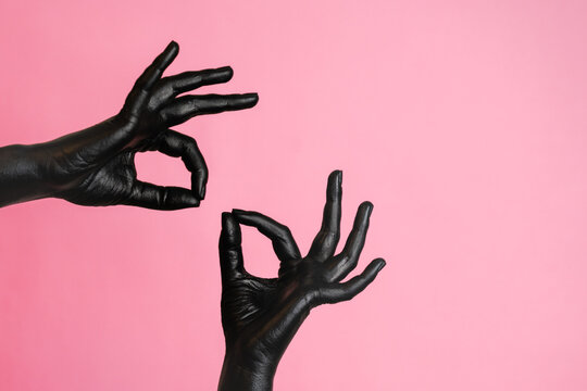 Gesticulation of black painted elegant woman's hands on her skin. High Fashion art concept