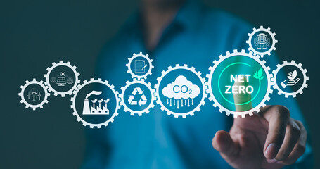 Carbon footprint concept. Man engaging with a conceptual showing net zero carbon emissions goal with related sustainability icons. carbon reduction, CO2 neutrality, Climate change, Sustainable energy,