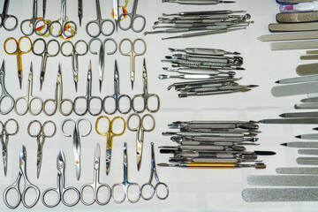 Set of many different scissors for manicure. Metal scissors on a white background. Close-up