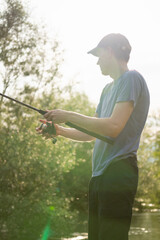 Man fishing on the mountain river at evening