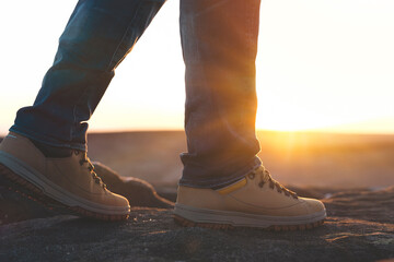 closeup of feet of man in special boots walking in the mountains reaching the destination and on...