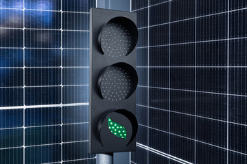 Green traffic light on a background of solar panels. Symbol of sustainable energy and development	