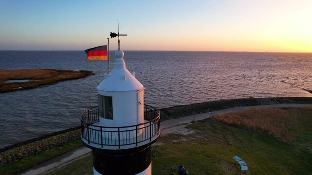 Lighthouse in the sunset - Wremen - Little Prussian lighthouse - side aerial view of the dome of the lighthouse with beacon in the sunset on the North Sea.