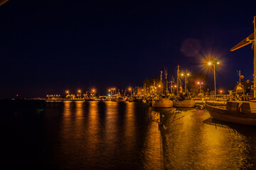 Fototapeta na wymiar Port in night lighting, light reflections in water