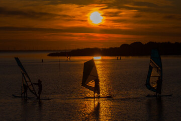 Windsurfing on the lake at sunset - 760825679