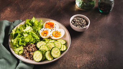 Bowl with quinoa, cucumber, boiled egg, lettuce and sesame seeds web banner