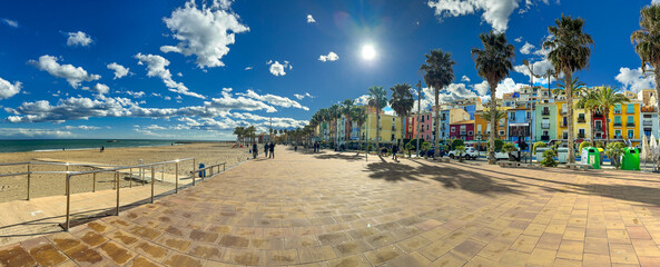 Fototapeta na wymiar Panoramic view of Villajoyosa beach promenade with landmark colorful old town homes in a sunny day, on the Mediterranean coast of Spain.