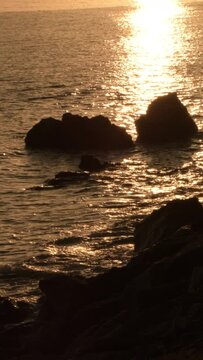 Rocks in shore at sunset. 4K Vertical