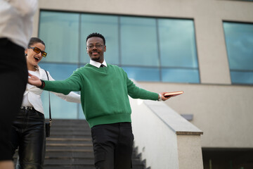 Young male professional using mobile phone outside modern office building, technology and business concept.