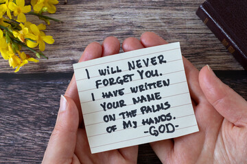Hands holding inspiring handwritten Christian message about God's faithful love, mercy, grace,...