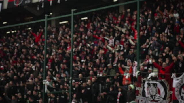 a blurred spot, a football match in sunny weather, the stands at stadiums are filled with people, fans celebrate the victory of their team, football fans burn fire, fans wave team flags