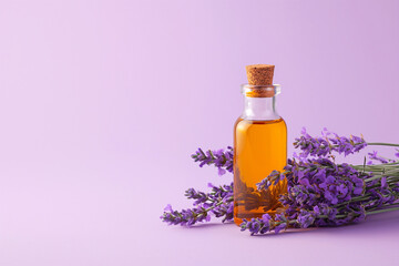 Obraz na płótnie Canvas A bottle of essential oil with fresh lavender twigs on violet background. Essential Aromatic oil, lavender flowers. Aromatherapy, skincare cosmetics products, alternative medicine and perfumery
