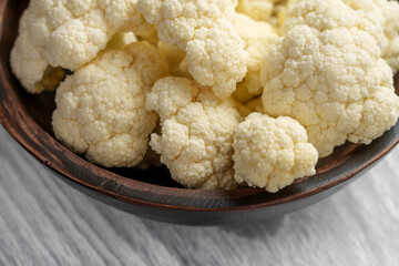Fresh cauliflower in wooden bowl. Raw vegetable dietary ingredients