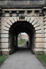 Ancient stone archway with person walking through