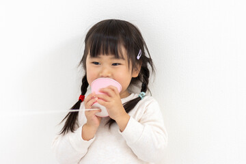 糸電話で遊ぶ女の子（3歳、日本人）