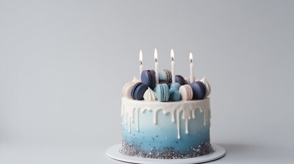 photo of a blue cake and macarons with candles lit, birthday celebration, on plain background with copy space