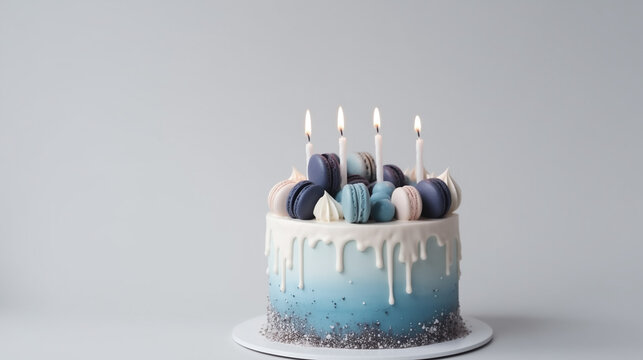 photo of a blue cake and macarons with candles lit, birthday celebration, on plain background with copy space