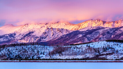 Pink Sunset Over Snowy Peaks of Colorado Rocky Mountains in Winter