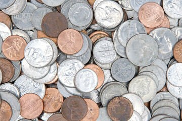 Close up on background of dirty American coins laying on a flat surface. Quarters, dimes, nickels and pennies.
