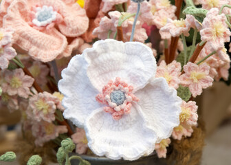 Close up on bouquet of beautiful hand made crochet flowers. White pansies and little peach flowers.