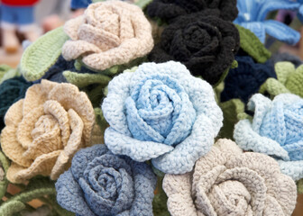 Close up on bouquet of beautiful hand crafted crochet flowers. Colorful roses.